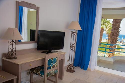 沙姆沙伊赫Queen Sharm Italian Club的一间带电视和镜子的客厅