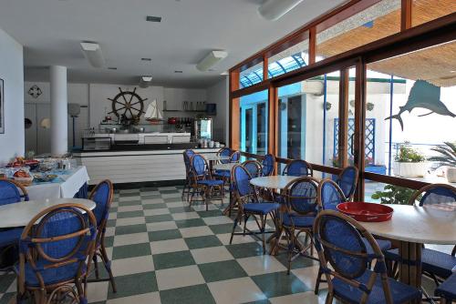 德瓦玛丽娜巴尼阿尔科巴里诺酒店的一间带桌椅的餐厅和一间厨房