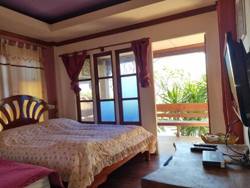 Ban Tha ThewawongSawasdee Sichang Resort的一间卧室设有一张床、一台电视和一个窗口。