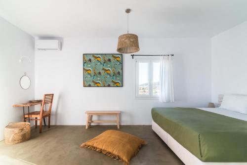 安提帕罗斯岛Statheros Garden的一间卧室配有一张绿色的床和一张桌子