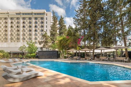 突尼斯金郁金香萨尔瓦多酒店的一个带椅子的游泳池和一间酒店