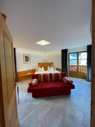 瓦格赖恩菲林豪斯曾特拉尔旅馆的一间卧室配有红色的床和红色的沙发