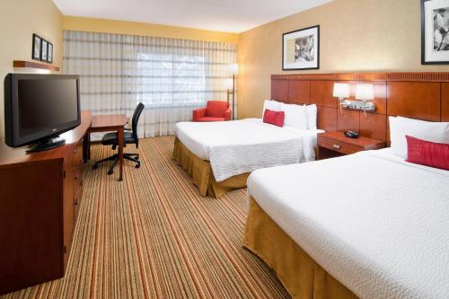 阿尔伯克基Courtyard by Marriott Albuquerque Airport的酒店客房设有两张床和一台平面电视。
