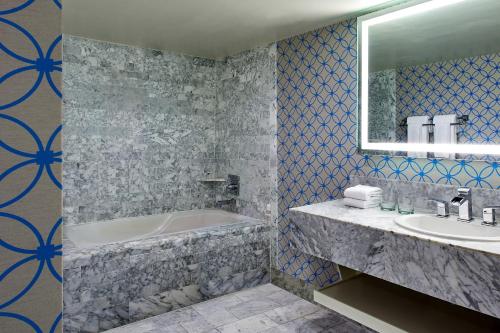 洛杉矶艾美德尔菲娜圣莫尼卡酒店的带浴缸、水槽和镜子的浴室