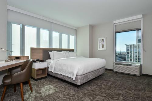 夏洛特SpringHill Suites by Marriott Charlotte City Center的酒店客房设有一张床、一张书桌和窗户。