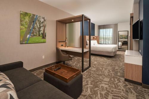 奥兰多SpringHill Suites by Marriott Winter Park的酒店客房带沙发以及一间卧室