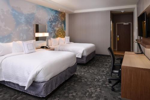 圣彼得斯圣彼得斯圣路易斯万怡酒店的酒店客房配有两张床和一张书桌