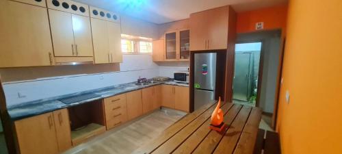 普拉亚Helton´s Residence的厨房配有木桌和冰箱。