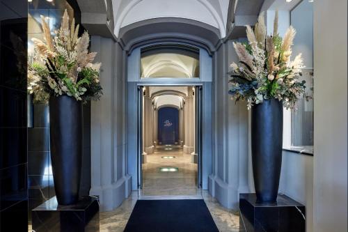 柏林Hotel Luc, Autograph Collection的走廊上摆放着两只蓝色大花瓶,上面摆放着鲜花