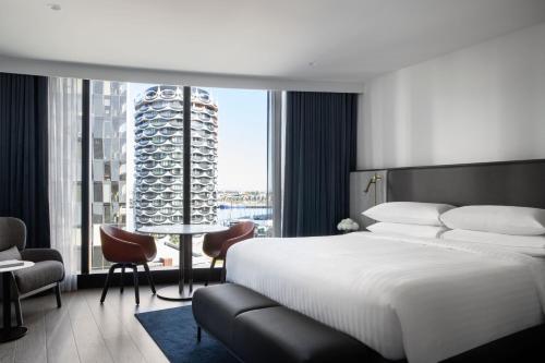 墨尔本Melbourne Marriott Hotel Docklands的一间卧室设有一张大床和一个大窗户