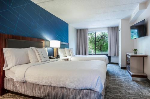 奥斯汀SpringHill Suites by Marriott Austin The Domain Area的酒店客房设有两张床和蓝色的墙壁。