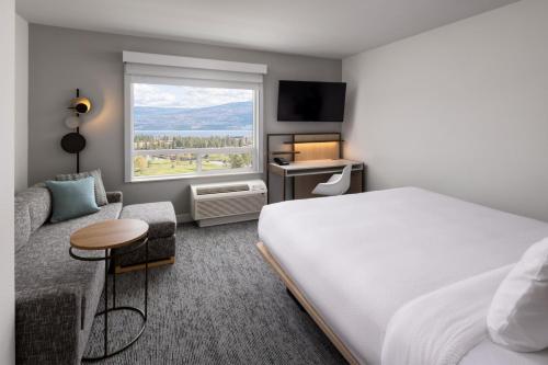 西基隆拿TownePlace Suites by Marriott West Kelowna的酒店客房设有床和窗户。