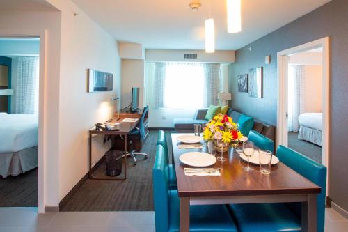 布朗克斯布朗克斯都会中心中庭原住客栈万豪酒店的一间带餐桌的房间和一间客厅