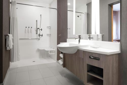 夏洛特SpringHill Suites by Marriott Charlotte Airport Lake Pointe的白色的浴室设有水槽和淋浴。