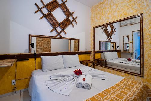 布罗塔斯Hotel Pousada Natural的一间卧室配有一张带两条毛巾和镜子的床