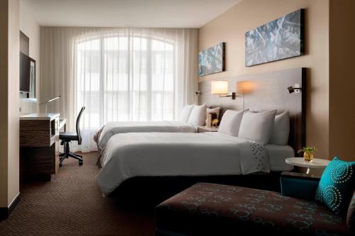 丹佛丹佛市中心万丽酒店的酒店客房配有两张床和一张书桌