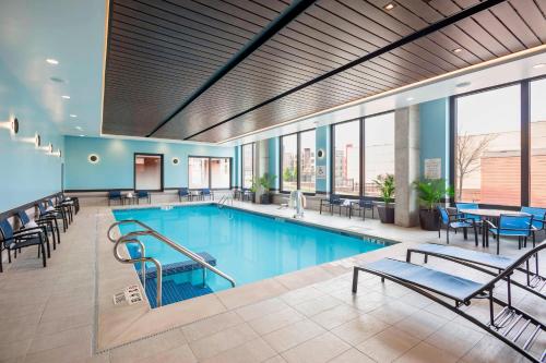麦迪逊SpringHill Suites Madison的大楼内一个带桌椅的游泳池