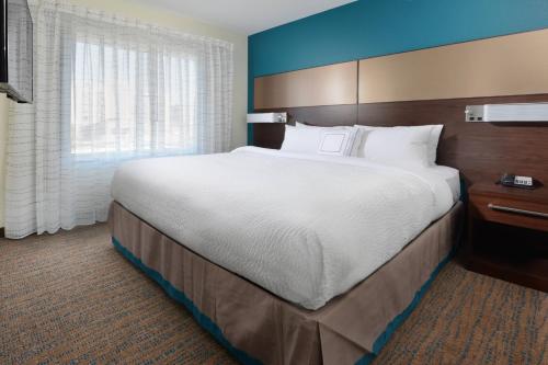 利特尔顿Residence Inn by Marriott Denver Southwest/Littleton的一间设有大床和窗户的酒店客房