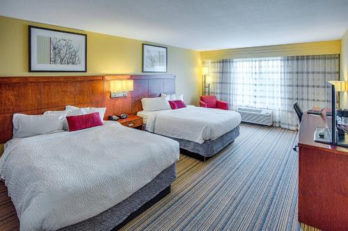 Moorhead明尼苏达州穆尔黑德法戈庭院酒店的酒店客房设有两张床和电视。