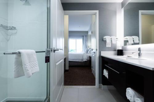 俄克拉何马城Residence Inn by Marriott Oklahoma City North/Quail Springs的带淋浴、盥洗盆和镜子的浴室