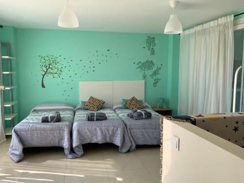 库列拉Nacaren Cullera的一间卧室设有两张床和蓝色的墙壁