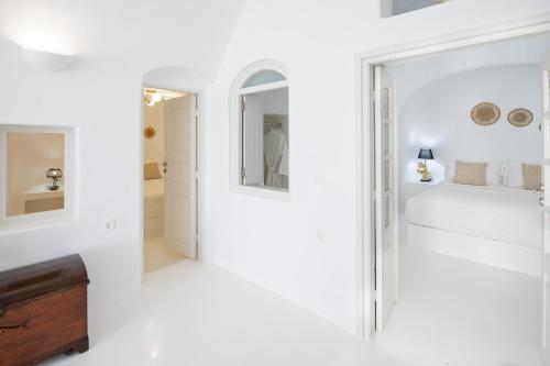 伊亚Ambi Villas Santorini的白色的客房配有床和镜子