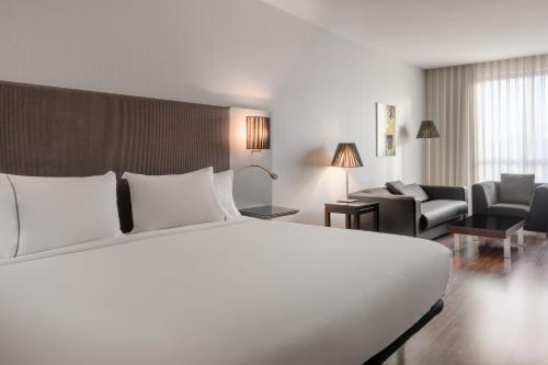 科斯拉达科斯拉达机场万豪AC酒店的一间带白色大床的卧室和一间客厅