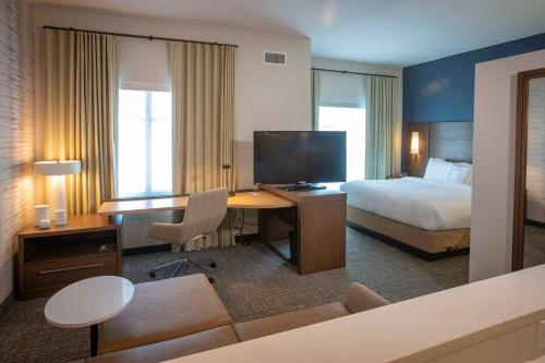 彭萨科拉Residence Inn by Marriott Pensacola Airport/Medical Center的酒店客房配有一张床和一张书桌及一台电视