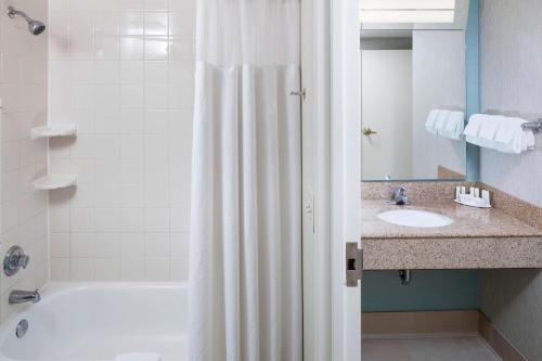卡罗来纳比奇卡罗莱纳卡特雅德海滩公寓的浴室配有淋浴帘和盥洗盆。