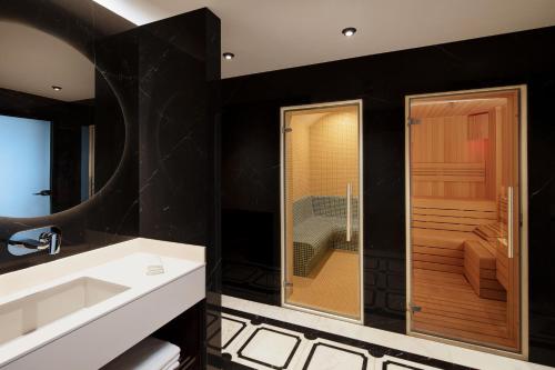 伊斯坦布尔Residence Inn by Marriott Istanbul Atasehir的一间带水槽和玻璃淋浴的浴室