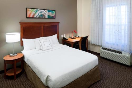 萨福克萨福克切萨皮克图恩宫殿酒店的酒店客房设有一张大床和一张书桌。