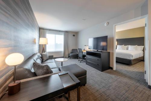 里士满Residence Inn by Marriott Richmond at the Notch的酒店客房设有一张沙发和一张床