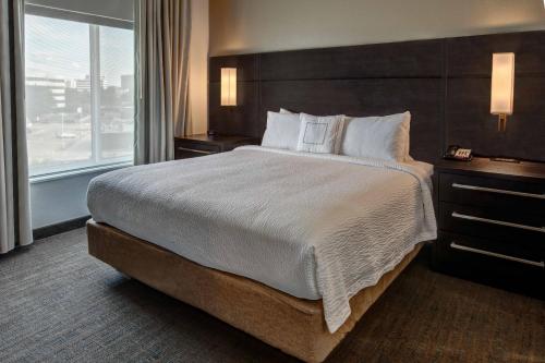 塔尔萨Residence Inn by Marriott Tulsa Midtown的一间卧室设有一张大床和一个大窗户