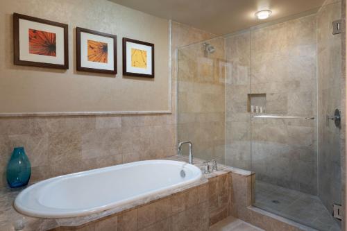 棕榈滩海岸笙歌岛棕榈滩万豪度假酒店暨Spa的带浴缸和玻璃淋浴间的浴室。