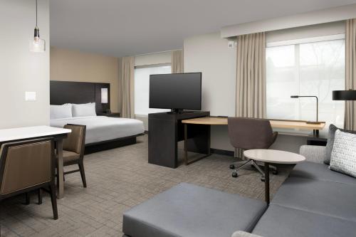 克拉克马斯Residence Inn by Marriott Portland Clackamas的酒店客房设有一张床和一张带电视的书桌。