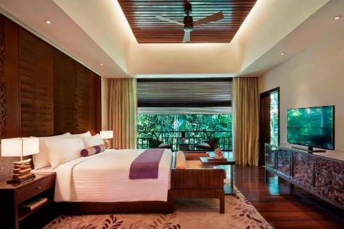 姆鲁姆鲁万豪度假酒店的一间卧室配有一张大床和电视