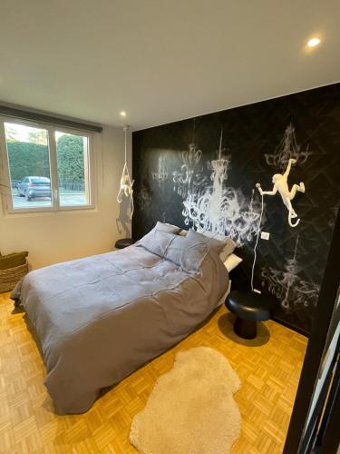 朗布依埃Très bel appartement T3 centre ville, commerces et gare的一间卧室配有一张床,墙上挂着绘画作品