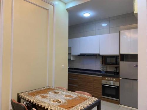 普特拉贾亚CheeAyu@ Putrajaya IOI Resort的一间带桌子的厨房和一间带白色橱柜的厨房