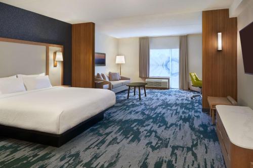 奥里利亚Fairfield by Marriott Inn & Suites Orillia的酒店客房设有一张大床和一张沙发。