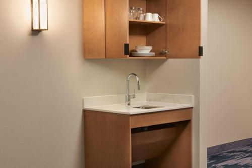 奥里利亚Fairfield by Marriott Inn & Suites Orillia的一个带水槽和木橱柜的厨房
