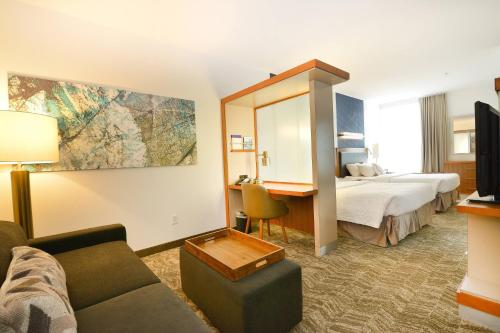 格兰福克格兰福克春山套房酒店的酒店客房设有沙发、床和书桌