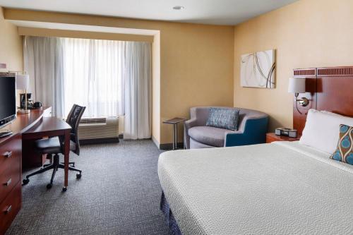 萨克拉门托万豪萨克拉门托加州展览中心万怡酒店的酒店客房配有一张床、一张桌子和一把椅子。