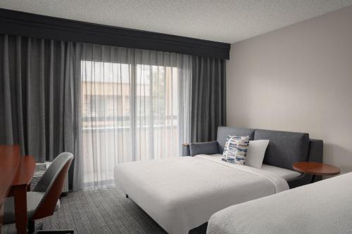 比弗顿Courtyard by Marriott Portland Beaverton的酒店客房设有床和窗户。