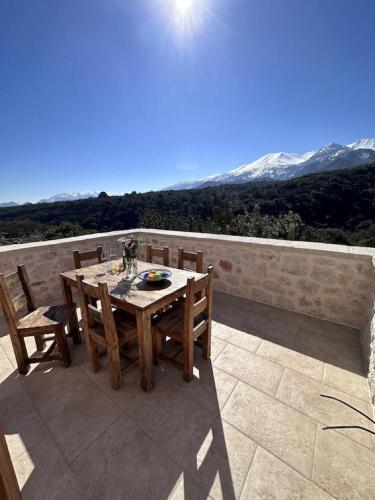 MelidhónionVilla Asteria的山景庭院里的一张木桌和椅子