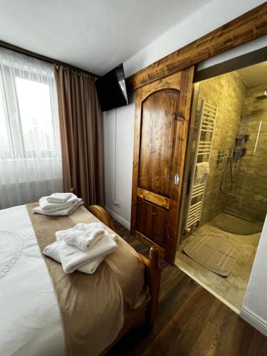 舒加塔格盐矿镇Rustic Maramureș的一间卧室设有淋浴和一张带毛巾的床。