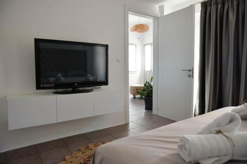 阿诺锡罗斯Κατοικία Uppolis με θέα τα νησιά的卧室配有白色墙壁上的平面电视。