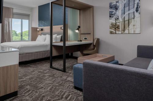 亨特斯维尔SpringHill Suites by Marriott Charlotte Huntersville的酒店客房,配有床和沙发