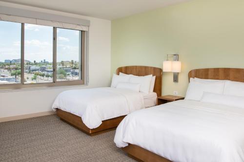 斯科茨Element Scottsdale at SkySong的配有窗户的酒店客房内的两张床