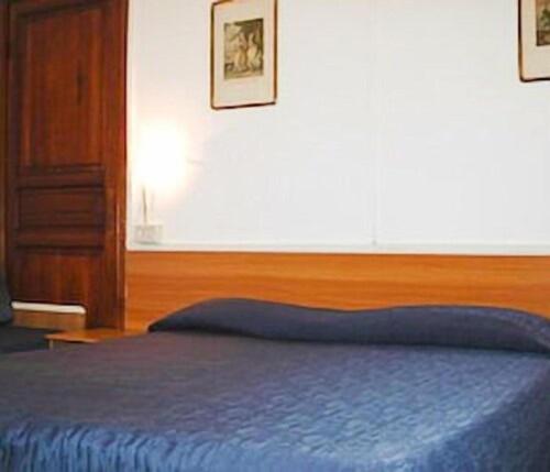 拉帕洛Hotel Fernanda的一间卧室配有一张蓝色的床和木制床头板