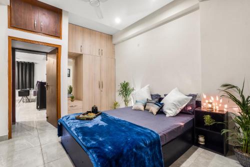 新德里Homlee-Luxurious 2BHK Apt with Kitchen near Metro的一间卧室配有一张带蓝色毯子的床
